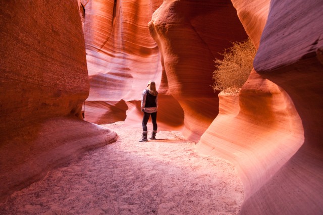A,Woman,Stands,Among,The,Ancient,Sandstone,Walls,Of,Canyon